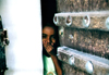 Seyun, Hadhramaut Governorate, Yemen: girl behind door, hiding her laughter - photo by N.Cabana