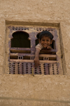 Shibam, Hadhramaut Governorate, Yemen: boy looking out window - Old Walled City of Shibam - mud building - photo by J.Pemberton